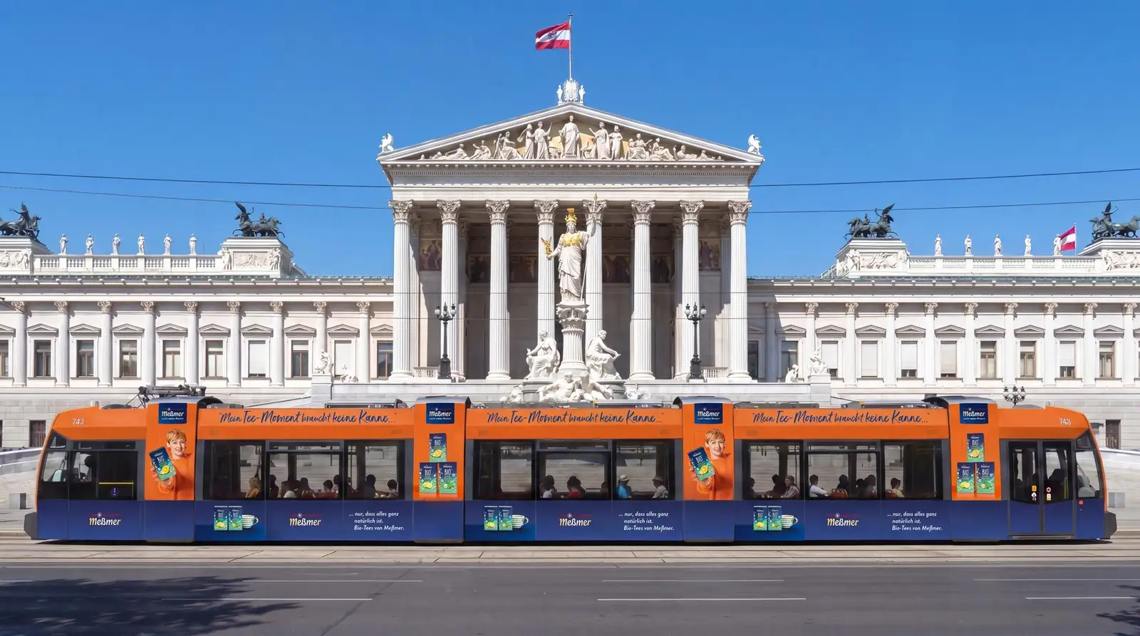 Straßenbahn mit Meßmer-Branding vor dem Parlament in Wien