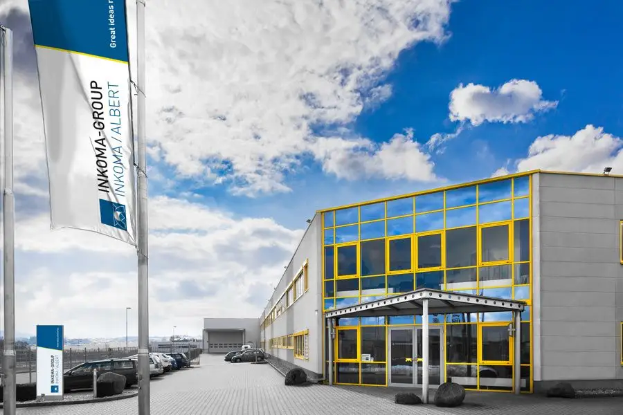 Firmenfahne mit Inkoma-Group-Logo vor dem Firmengebäude